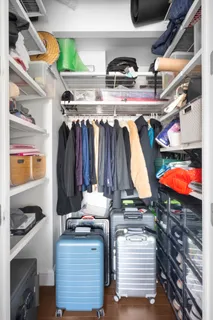 a view of walk in closet with clothes and shoes