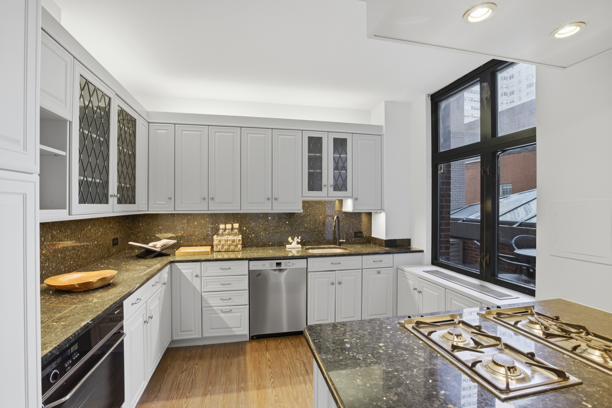 188 East 70th Street, Unit 3A Manhattan, NY 10021 - Photo 6 of 18 a kitchen with a sink stove and cabinets
