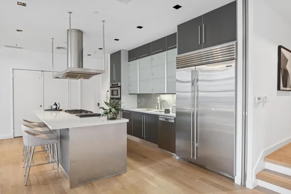 a kitchen with stainless steel appliances granite countertop a sink a stove and a refrigerator