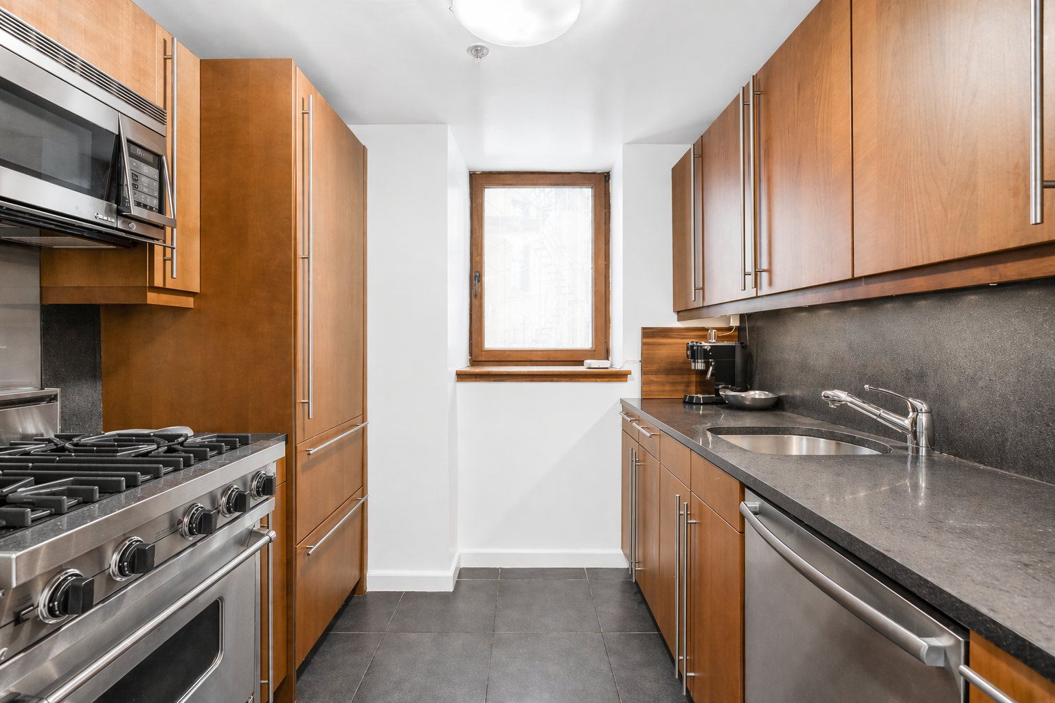 305 2nd Avenue, Unit 518 Manhattan, NY 10003 - Photo 3 of 19 a kitchen with stainless steel appliances granite countertop a sink stove and cabinets