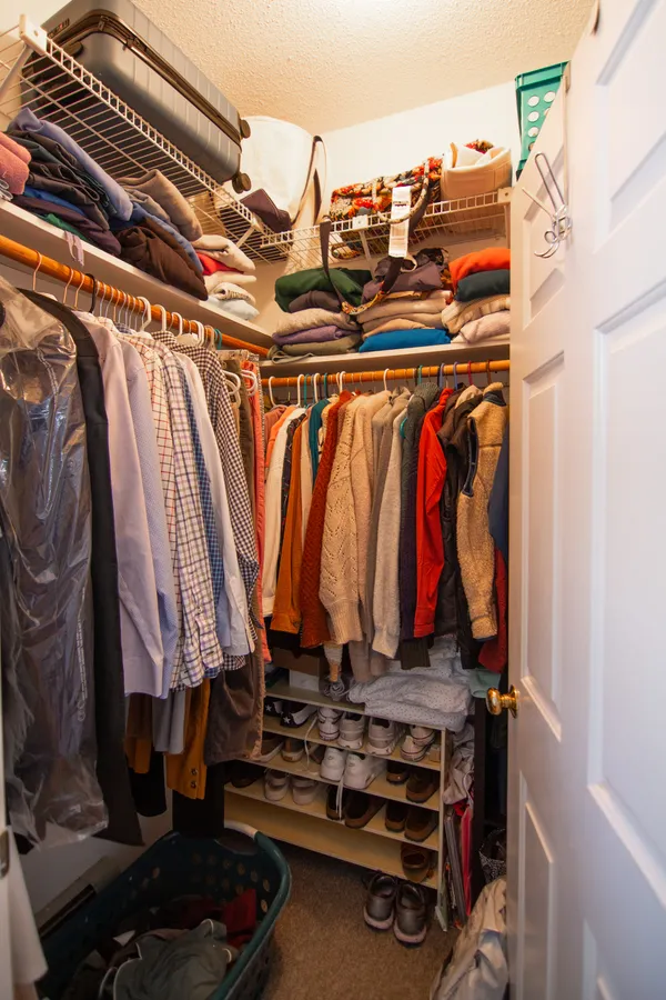 a view of walk in closet with clothes and shoes