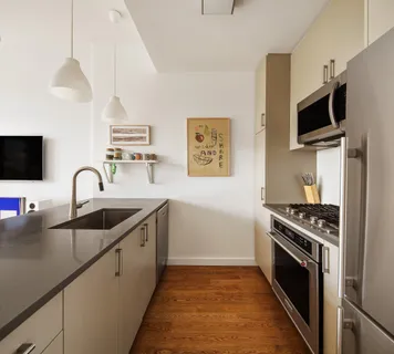 a kitchen with stainless steel appliances granite countertop a sink a stove and a microwave