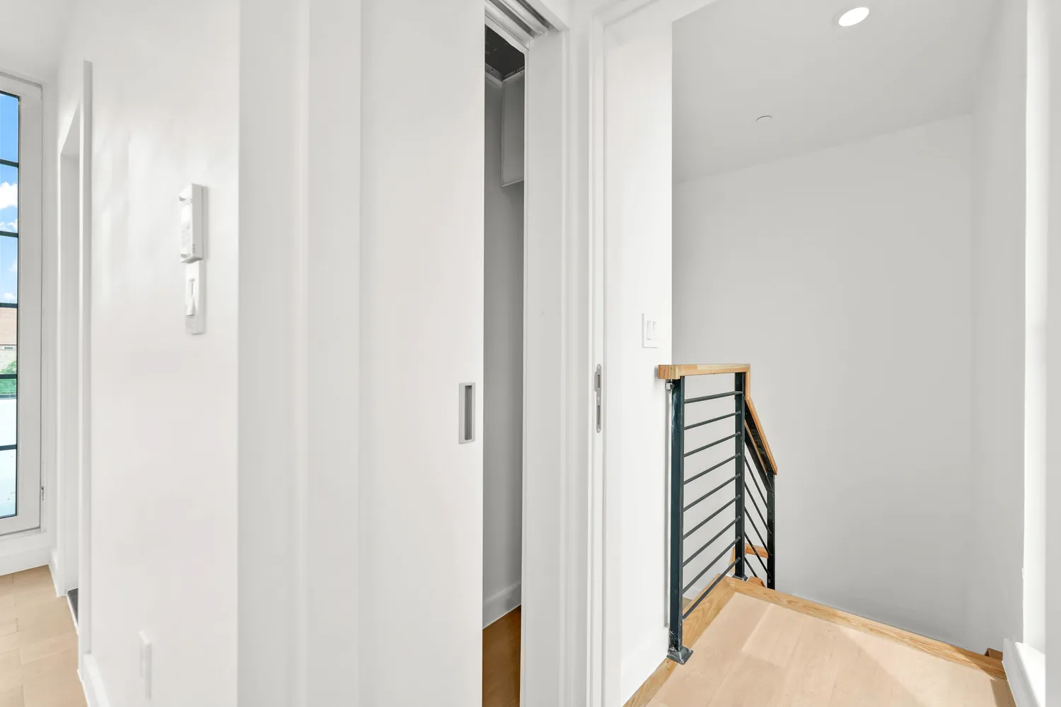 a view of a hallway with wooden floor and entryway