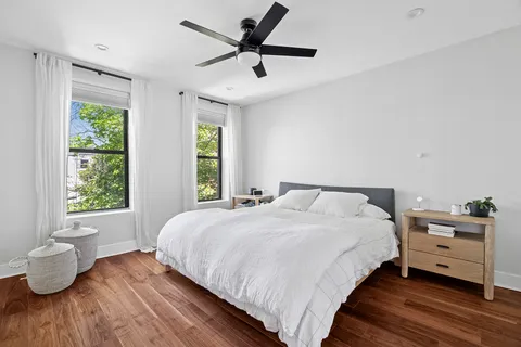 a bedroom with a bed and wooden floor