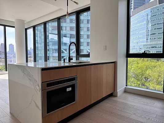 4507 Court Square, Unit 8D Queens, NY 11101 - Photo 25 of 28 a kitchen with stainless steel appliances granite countertop a stove and a microwave