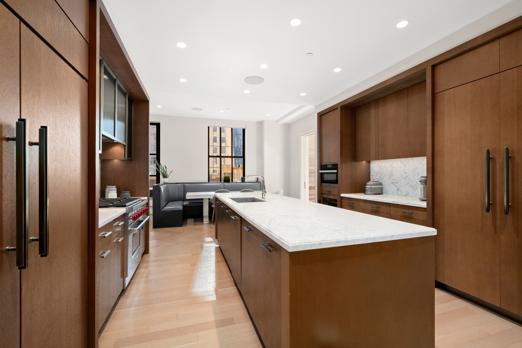 100 Barclay Street, Unit 21AD Manhattan, NY 10007 - Photo 7 of 40 a kitchen with stainless steel appliances a refrigerator a sink dishwasher and a stove with wooden floor