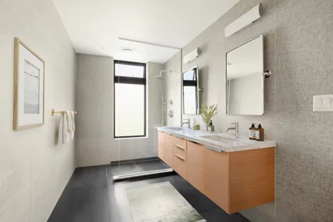 a bathroom with a double vanity sink a mirror and a bathtub