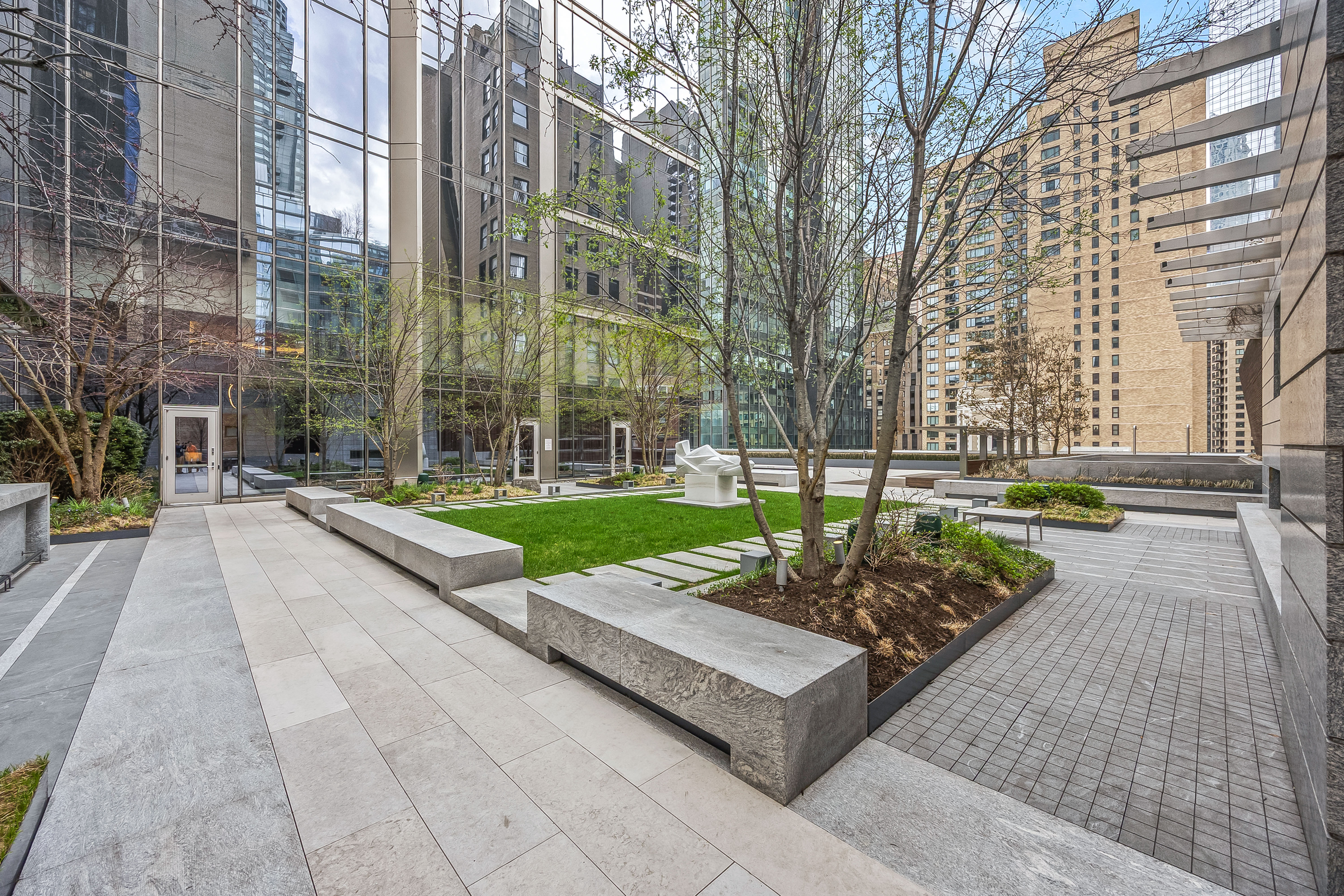 217 West 57th Street, Unit 36D Manhattan, NY 10019 - Photo 22 of 26 a view of a building with a garden and trees