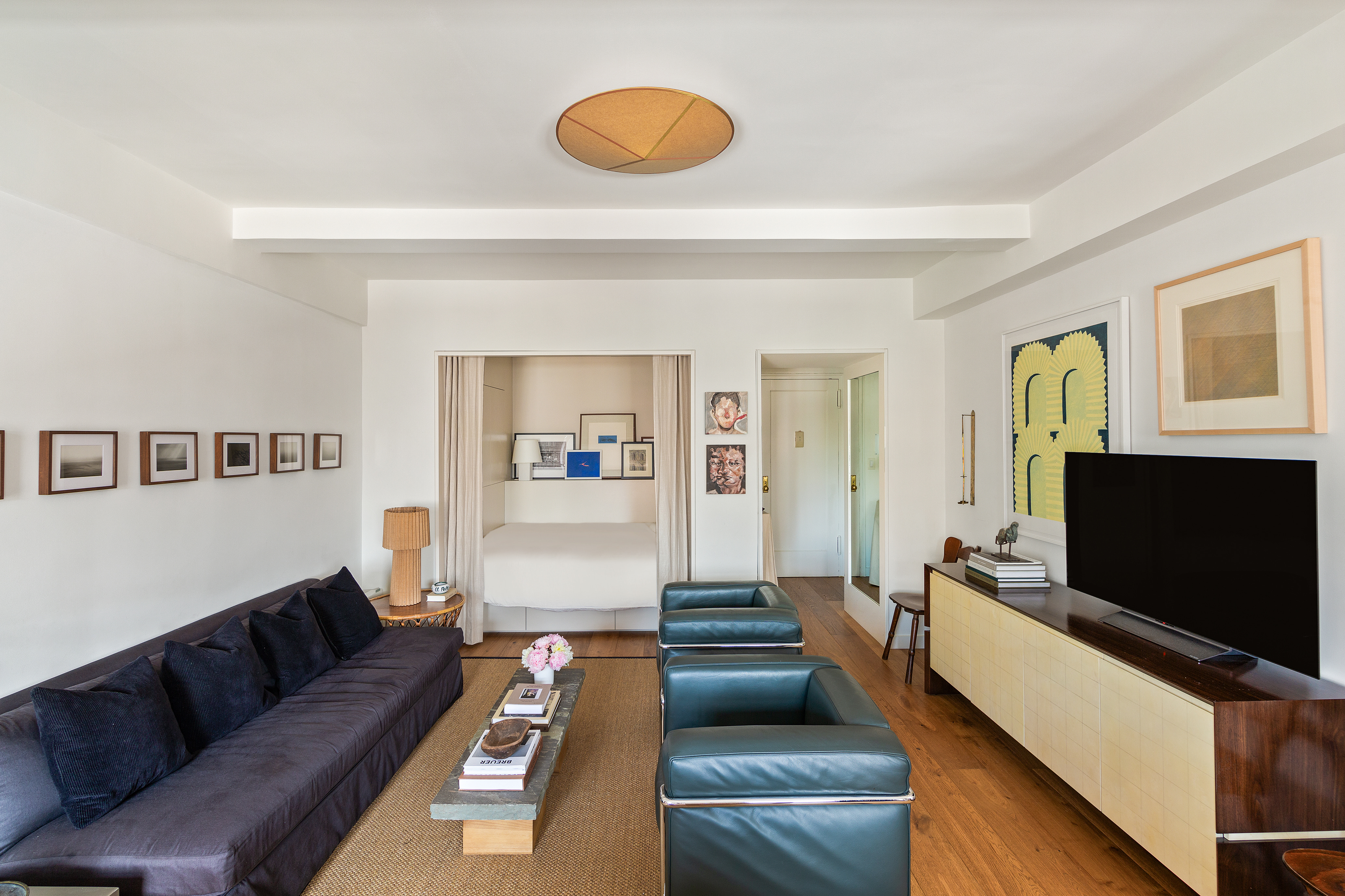 161 West 16th Street, Unit 12D Manhattan, NY 10011 - Photo 3 of 8 a living room with furniture and a flat screen tv