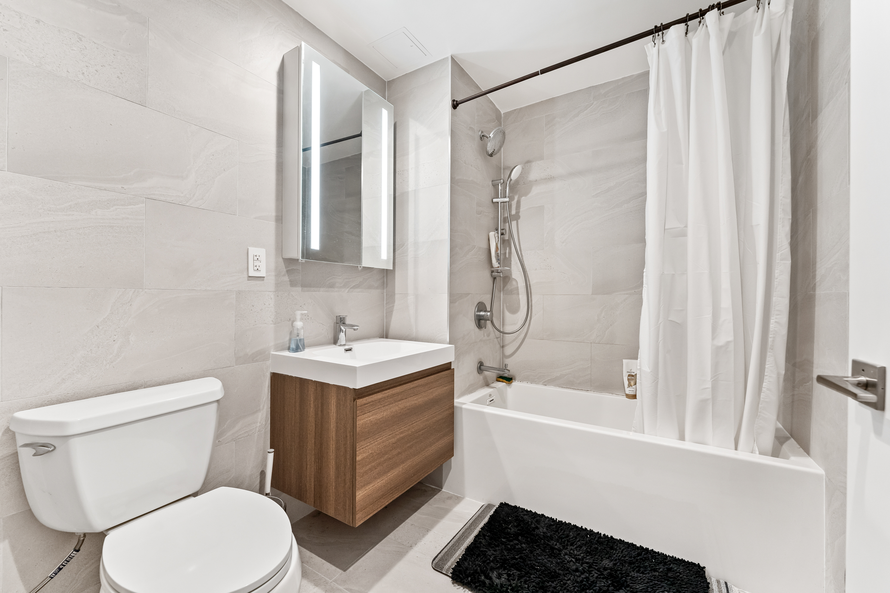 14-33 31st Avenue, Unit 5H Queens, NY 11106 - Photo 7 of 10 a bathroom with a sink toilet and shower