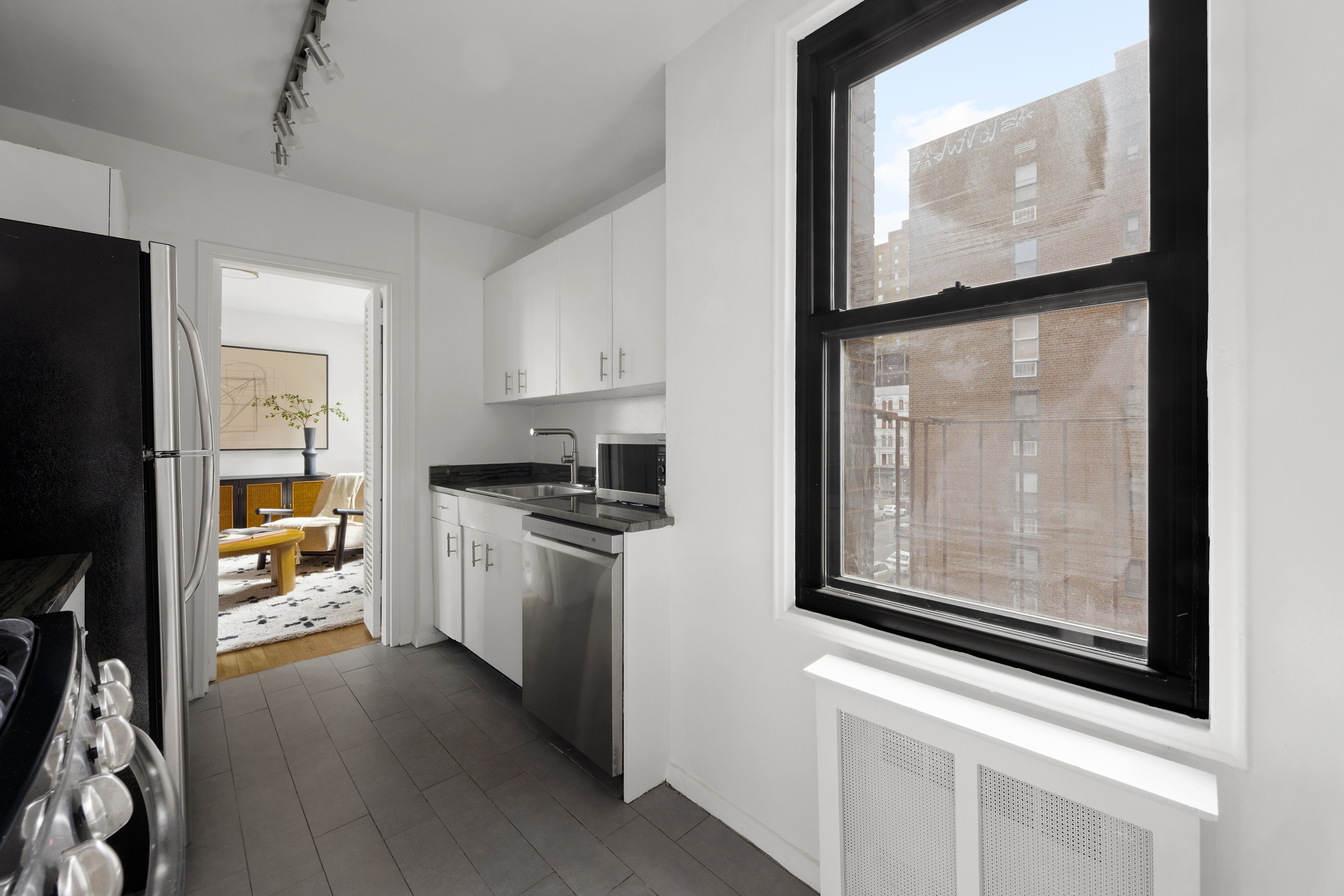 140 7th Avenue, Unit 4L Manhattan, NY 10011 - Photo 9 of 14 a kitchen with stainless steel appliances a refrigerator and a stove top oven