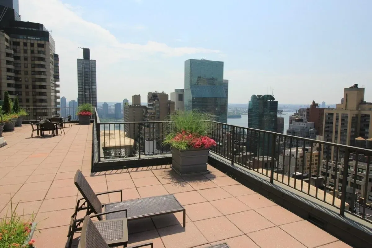 212 East 47th Street, Unit 21D Manhattan, NY 10017 - Photo 13 of 16 a view of a terrace with wooden benches