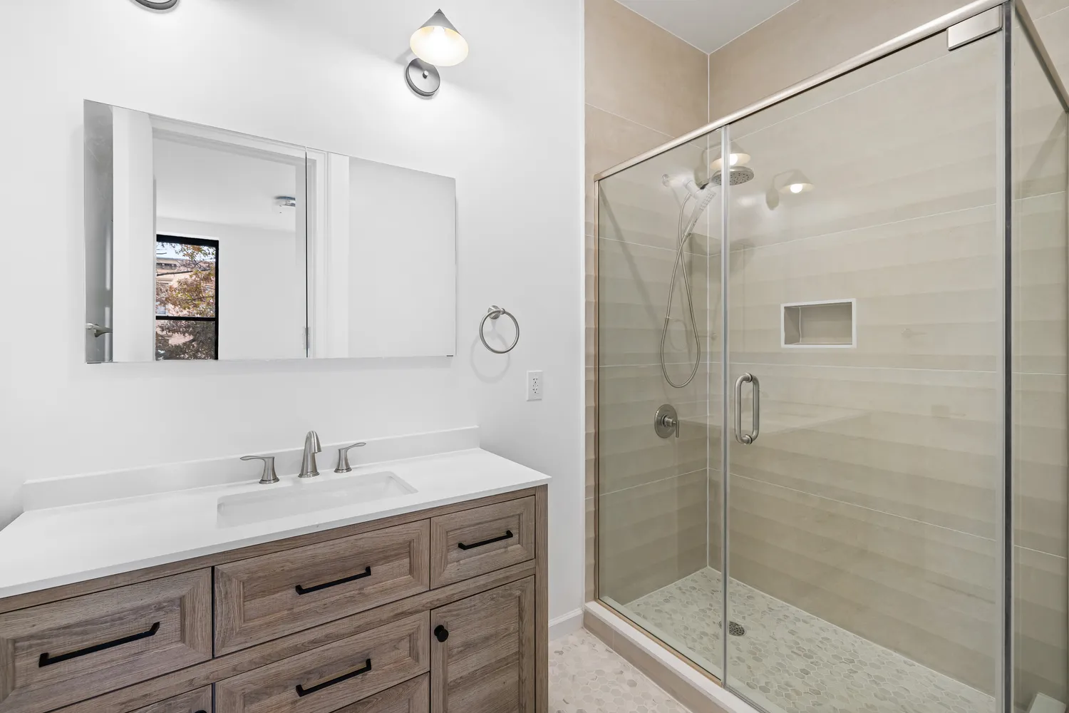 a bathroom with a shower sink and mirror