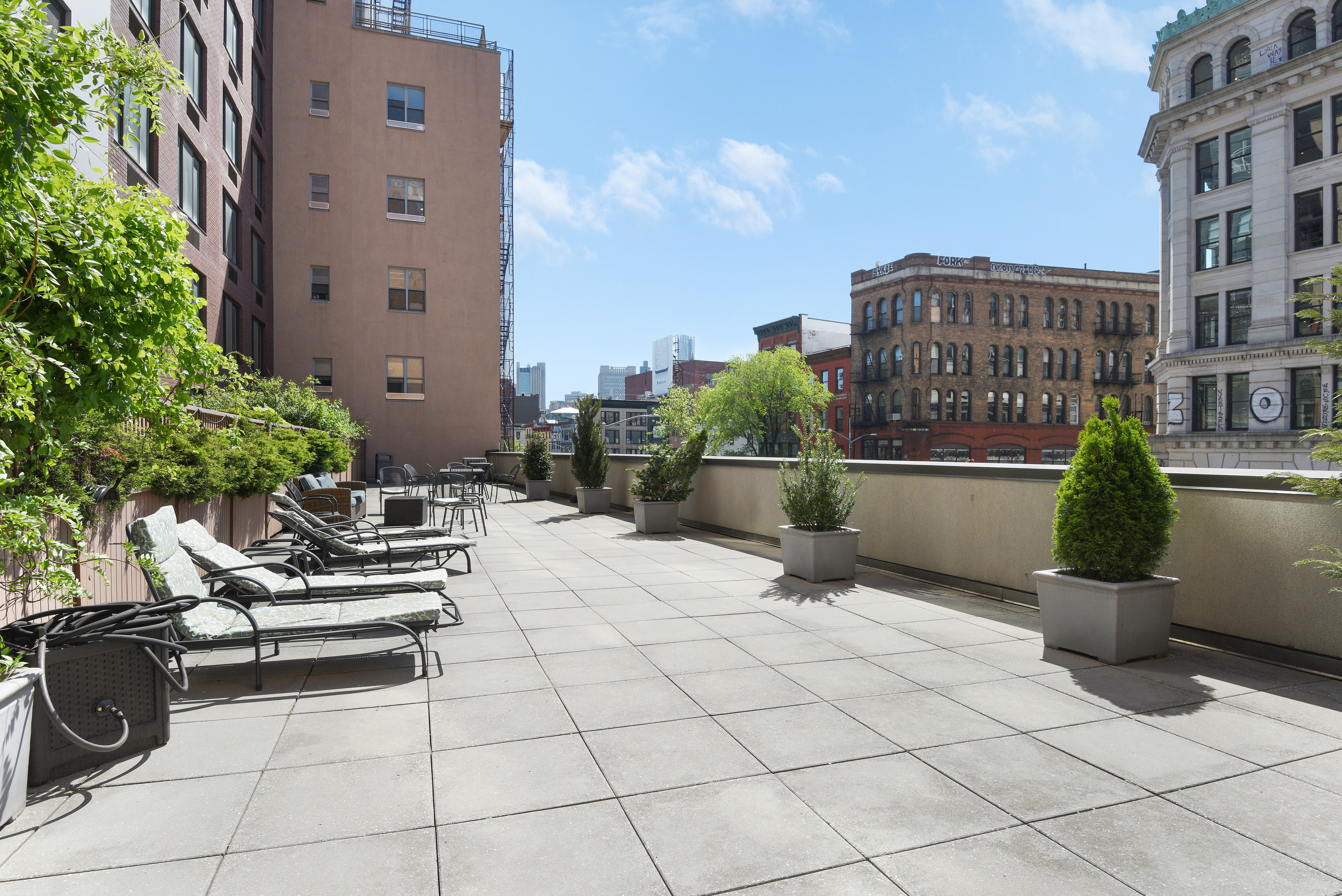 199 Bowery, Unit 11F Manhattan, NY 10002 - Photo 11 of 13 a view of a terrace with lawn chairs and potted plants