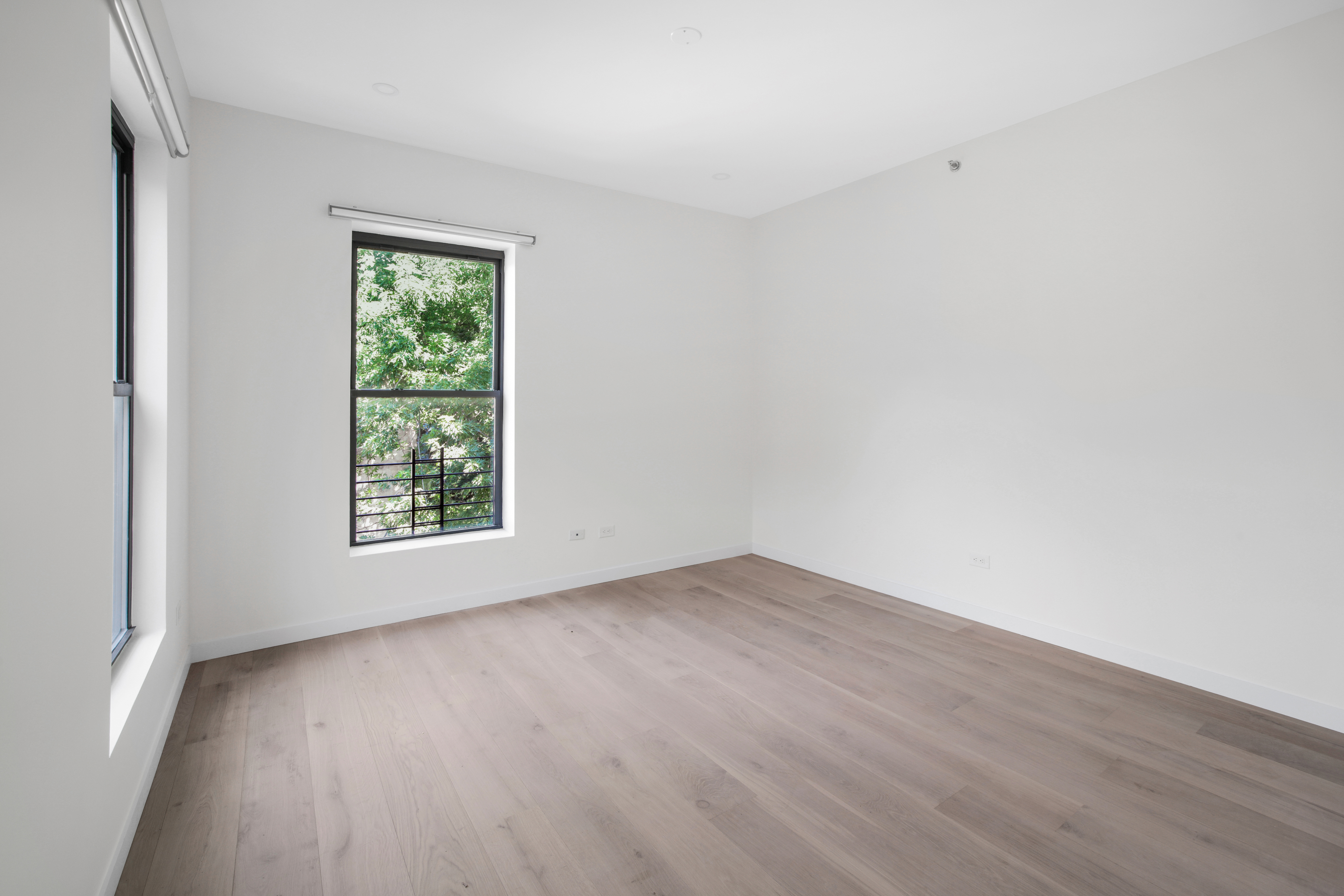 94 6th Avenue, Unit 3R Brooklyn, NY 11217 - Photo 5 of 12 an empty room with wooden floor and windows