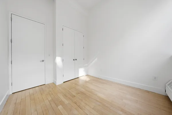 a view of empty room with wooden floor