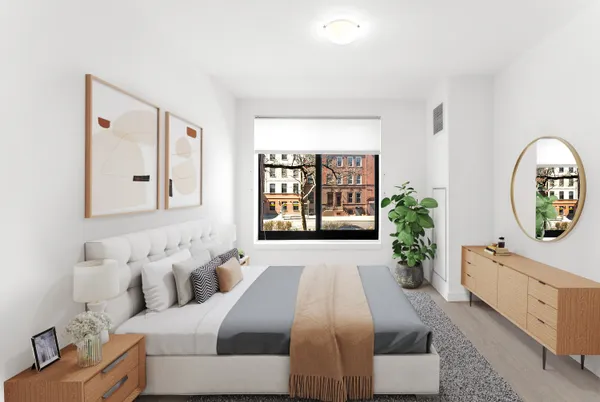 a spacious bedroom with a bed and a potted plant