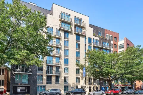 a front view of a building with lot of trees