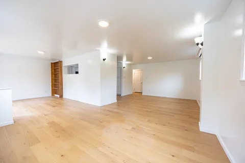 a view of an empty room and a kitchen