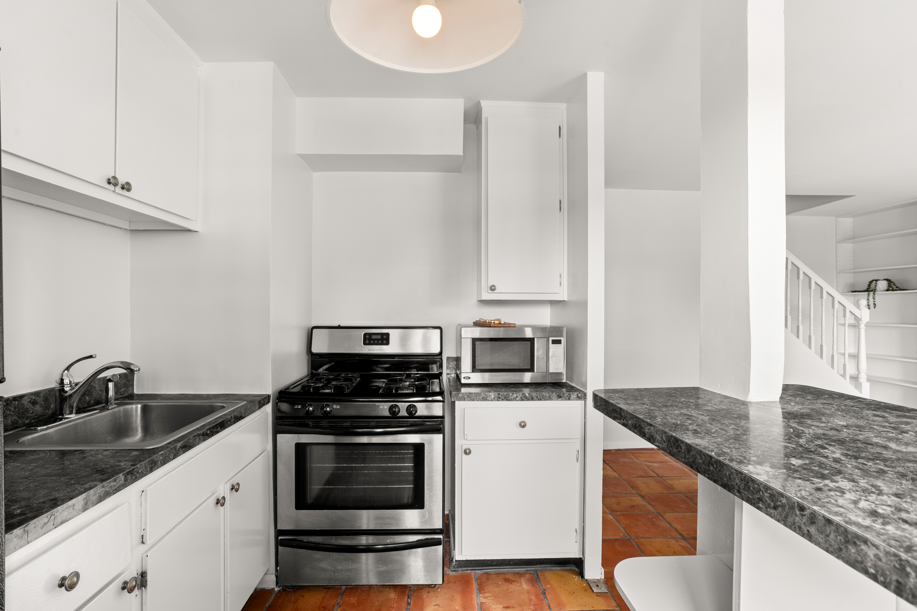609 Columbus Avenue, Unit 14E Manhattan, NY 10024 - Photo 7 of 24 a kitchen with granite countertop a sink stove and cabinets