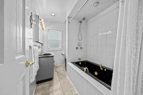 a bathroom with a tub sink and mirror