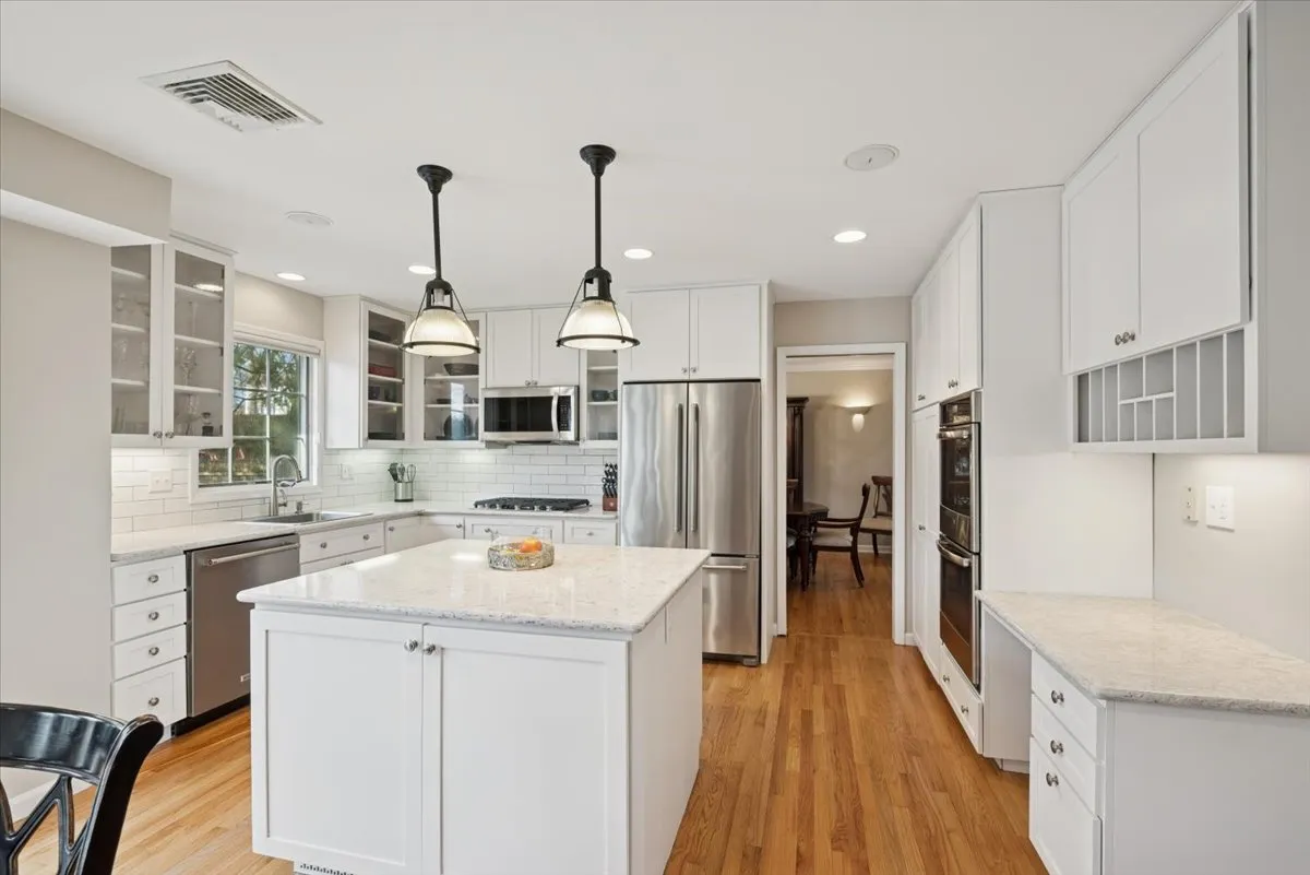 a kitchen with stainless steel appliances kitchen island a sink stove and refrigerator
