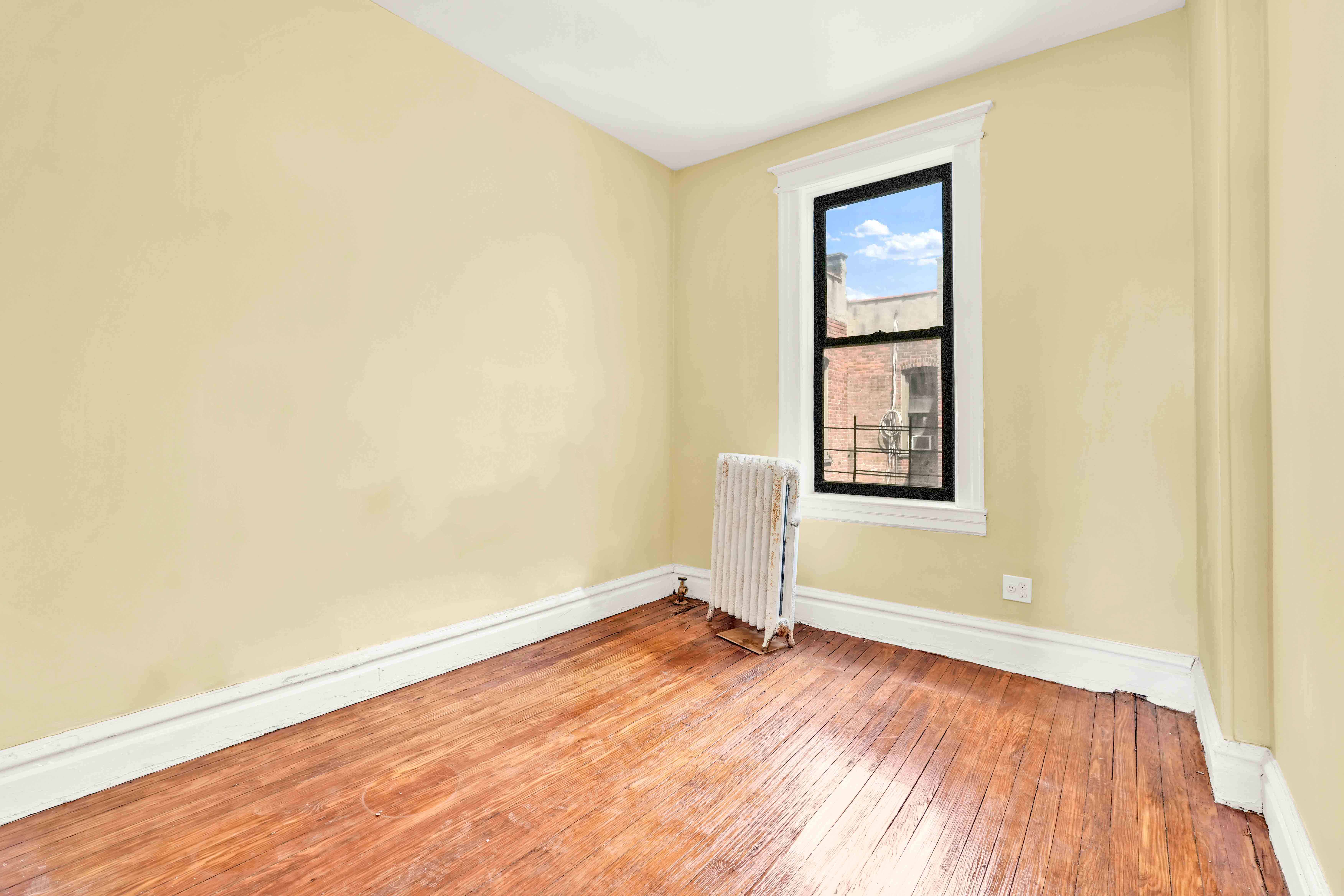 1770 Bedford Avenue Brooklyn, NY 11225 - Photo 19 of 50 an empty room with wooden floor and windows