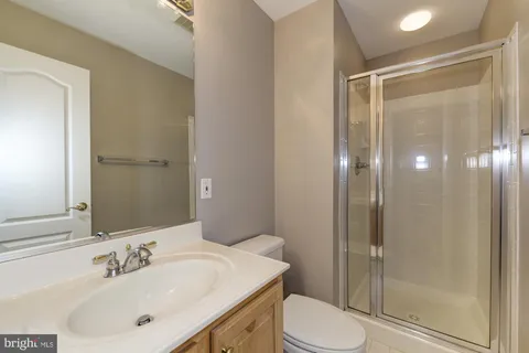 a bathroom with a sink vanity mirror and toilet