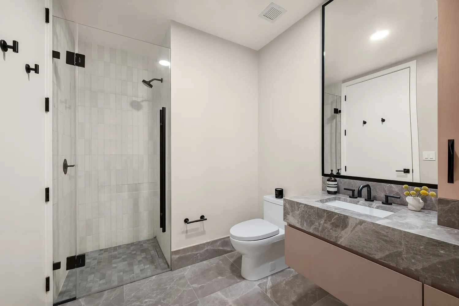 a bathroom with a granite countertop sink toilet and shower