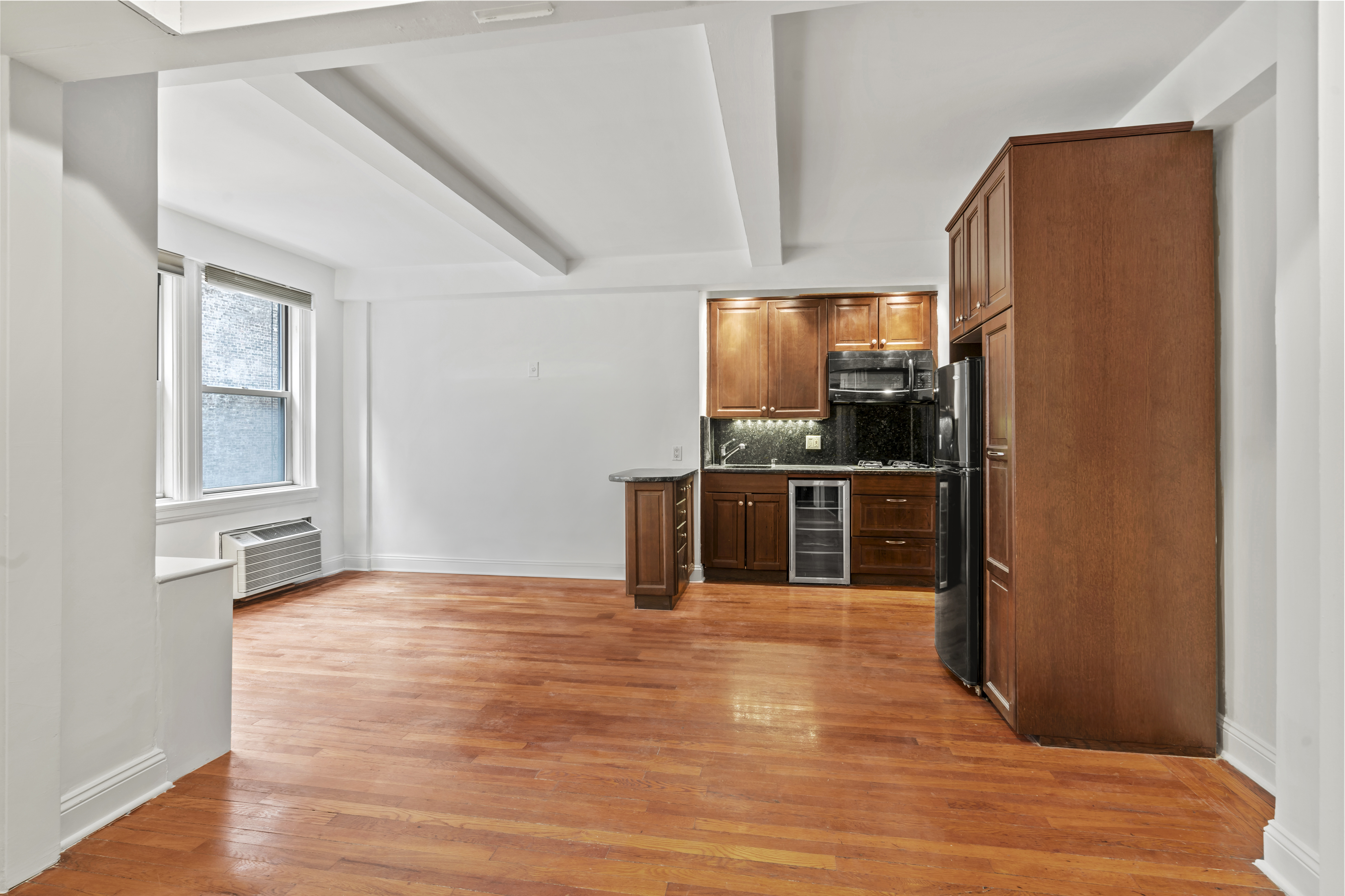 155 East 49th Street, Unit 8C Manhattan, NY 10017 - Photo 5 of 10 a kitchen with stainless steel appliances a refrigerator and a stove top oven