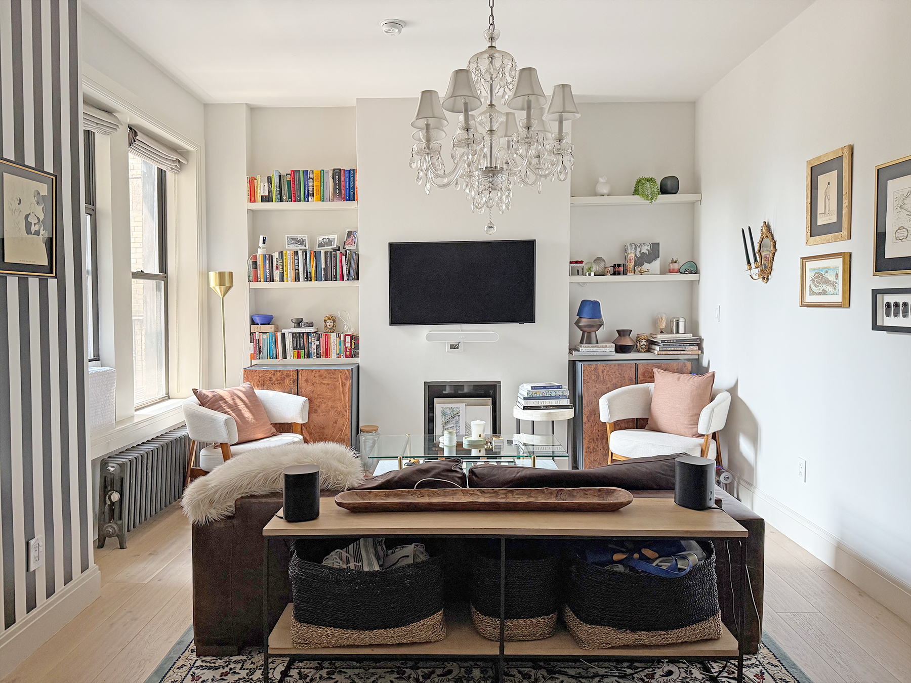 a living room with furniture a flat screen tv and a chandelier