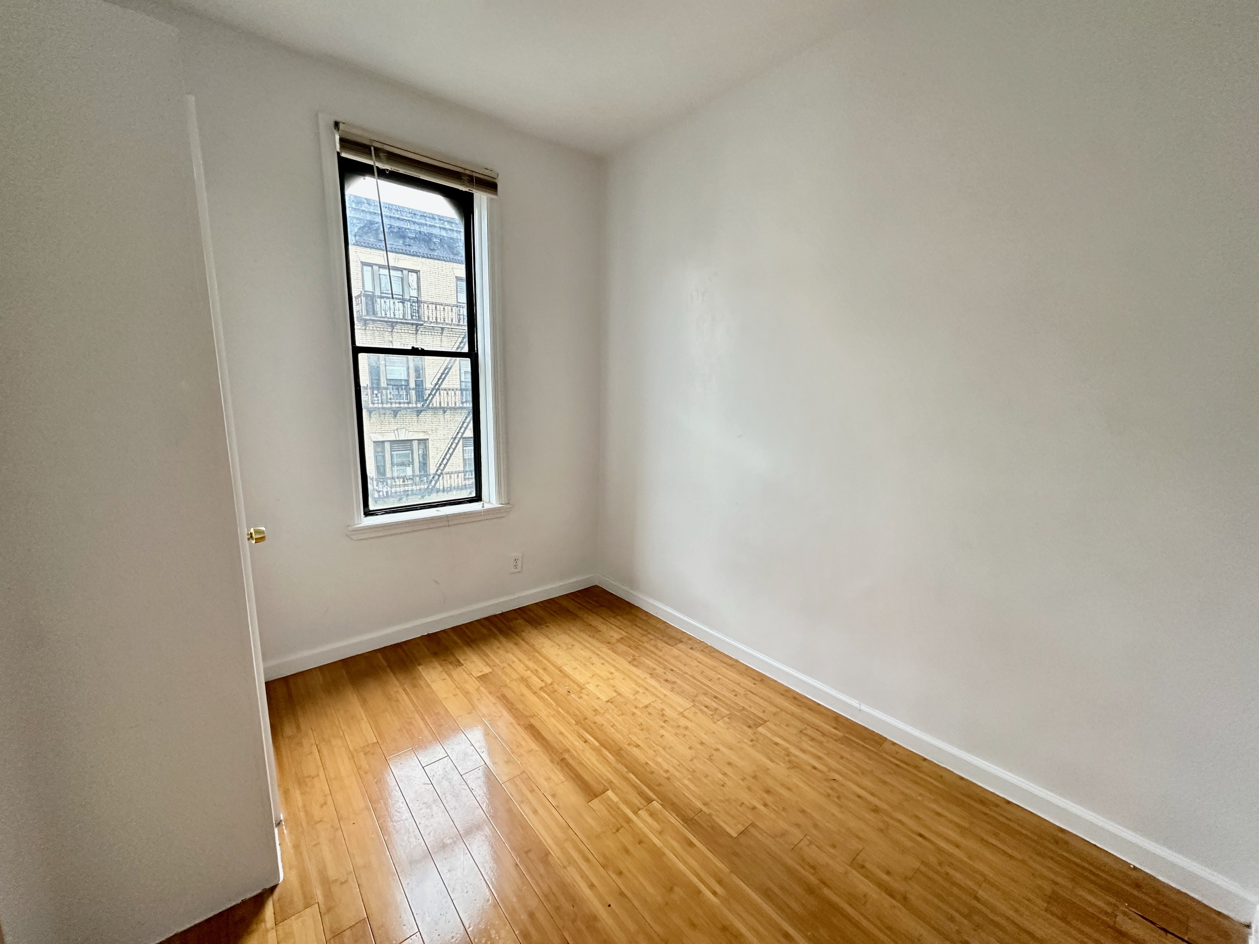 541 West 144th Street, Unit 17 Manhattan, NY 10031 - Photo 5 of 6 an empty room with wooden floor and windows