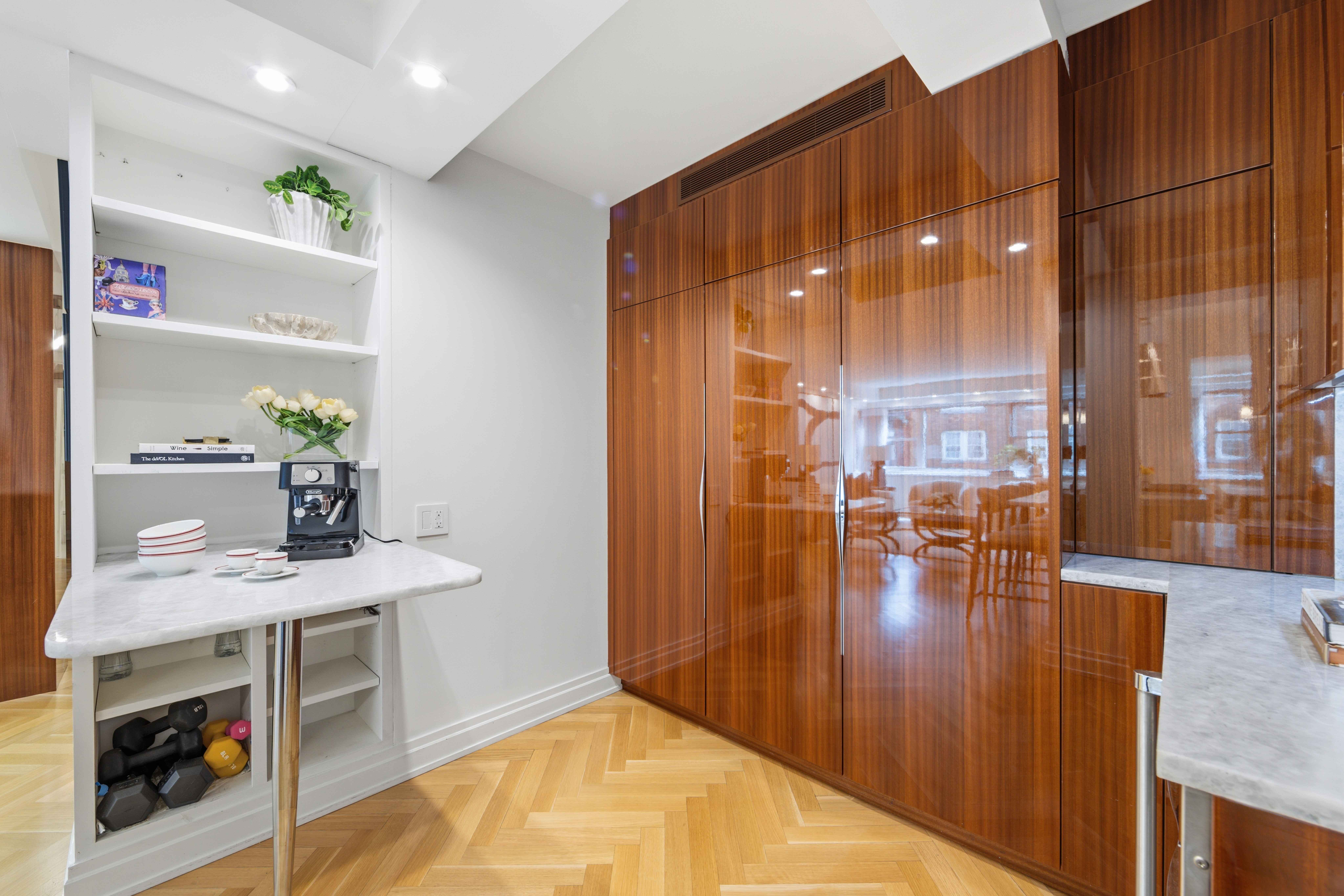 40 East 78th Street, Unit 5E Manhattan, NY 10075 - Photo 8 of 23 a kitchen with stainless steel appliances a dining table chairs and chandelier