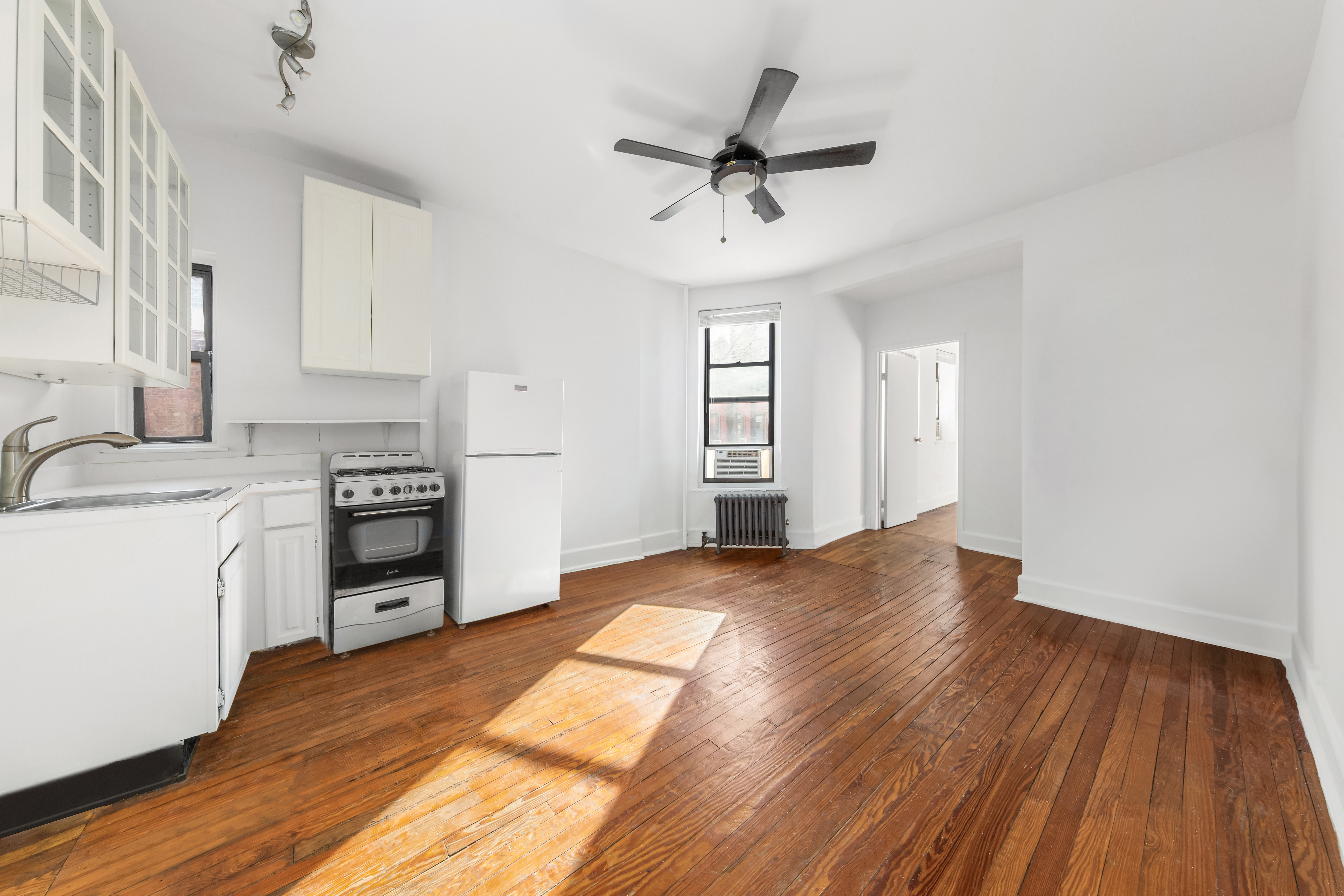 406 West 47th Street, Unit 2D Manhattan, NY 10036 - Photo 2 of 7 a view of a kitchen with a sink cabinet and a window