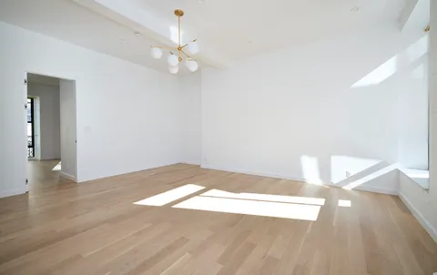 a view of a big room with wooden floor and windows