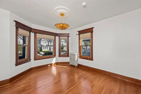 an empty room with windows and wooden floor