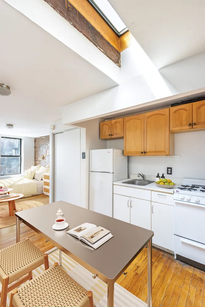 a kitchen with a refrigerator a stove top oven cabinets a dining table and chairs