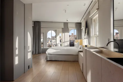 a living room with stainless steel appliances furniture and a large window