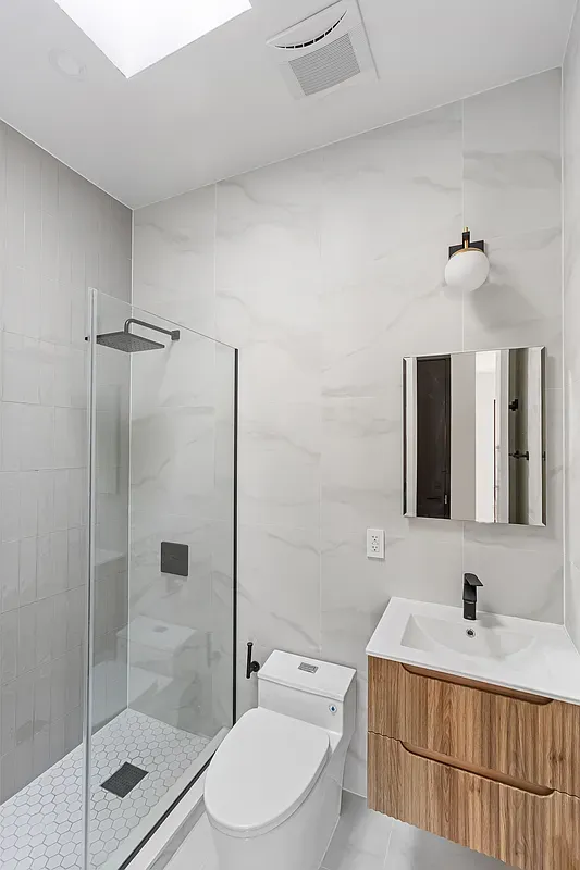 a bathroom with a granite countertop sink toilet a mirror a shower and vanity