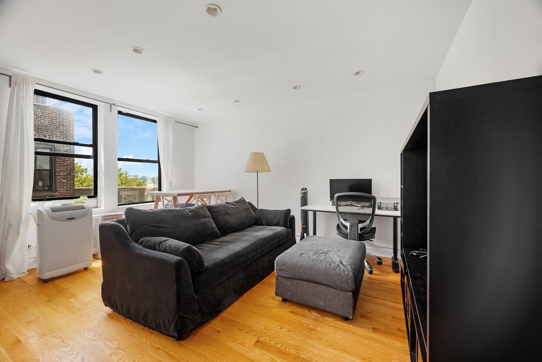 750 Riverside Drive, Unit 6B Manhattan, NY 10031 - Photo 2 of 8 a living room with furniture and a flat screen tv