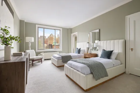 a bedroom with two beds and potted plant