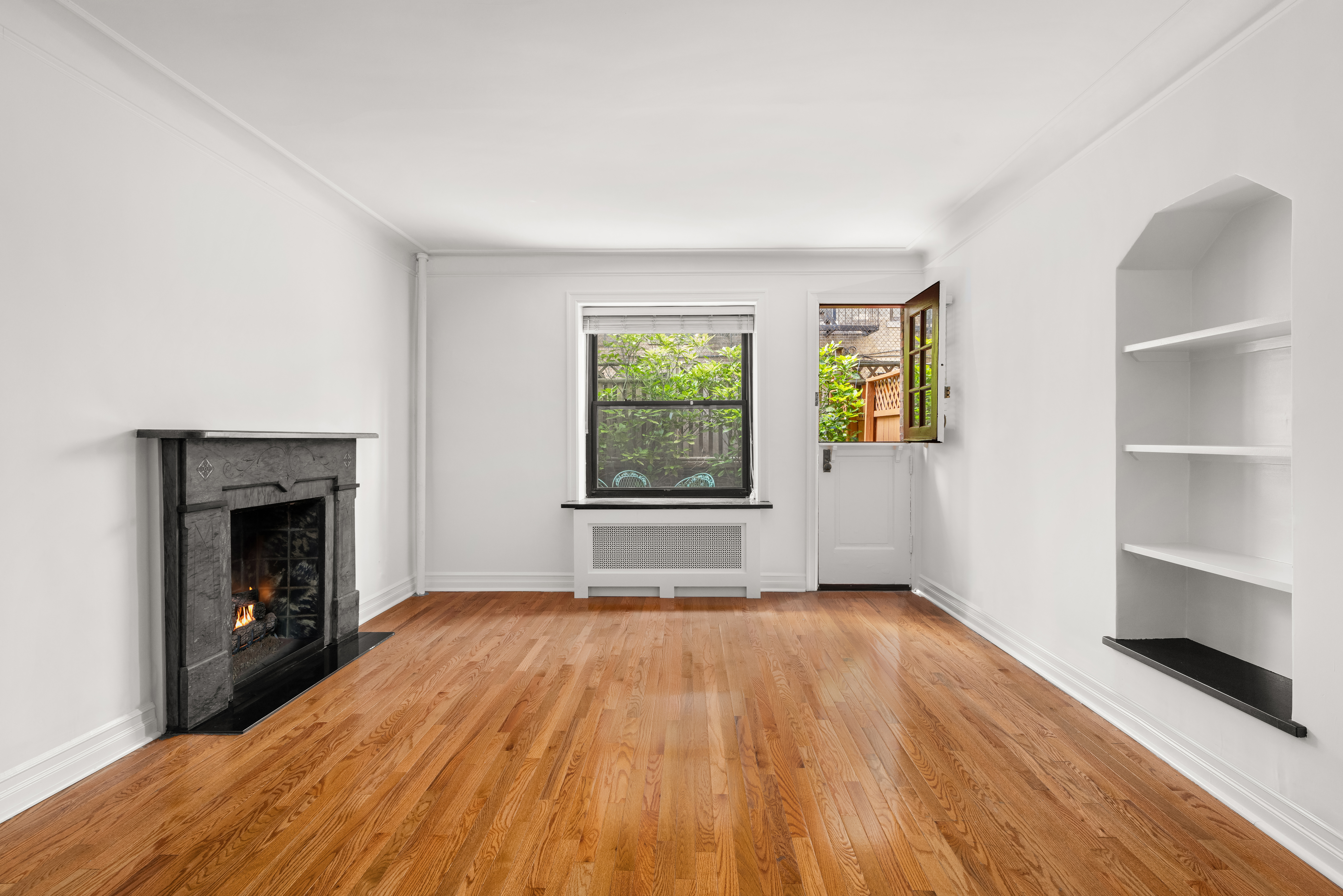 436 East 58th Street, Unit 1C Manhattan, NY 10022 - Photo 3 of 14 a view of empty room with wooden floor and fireplace