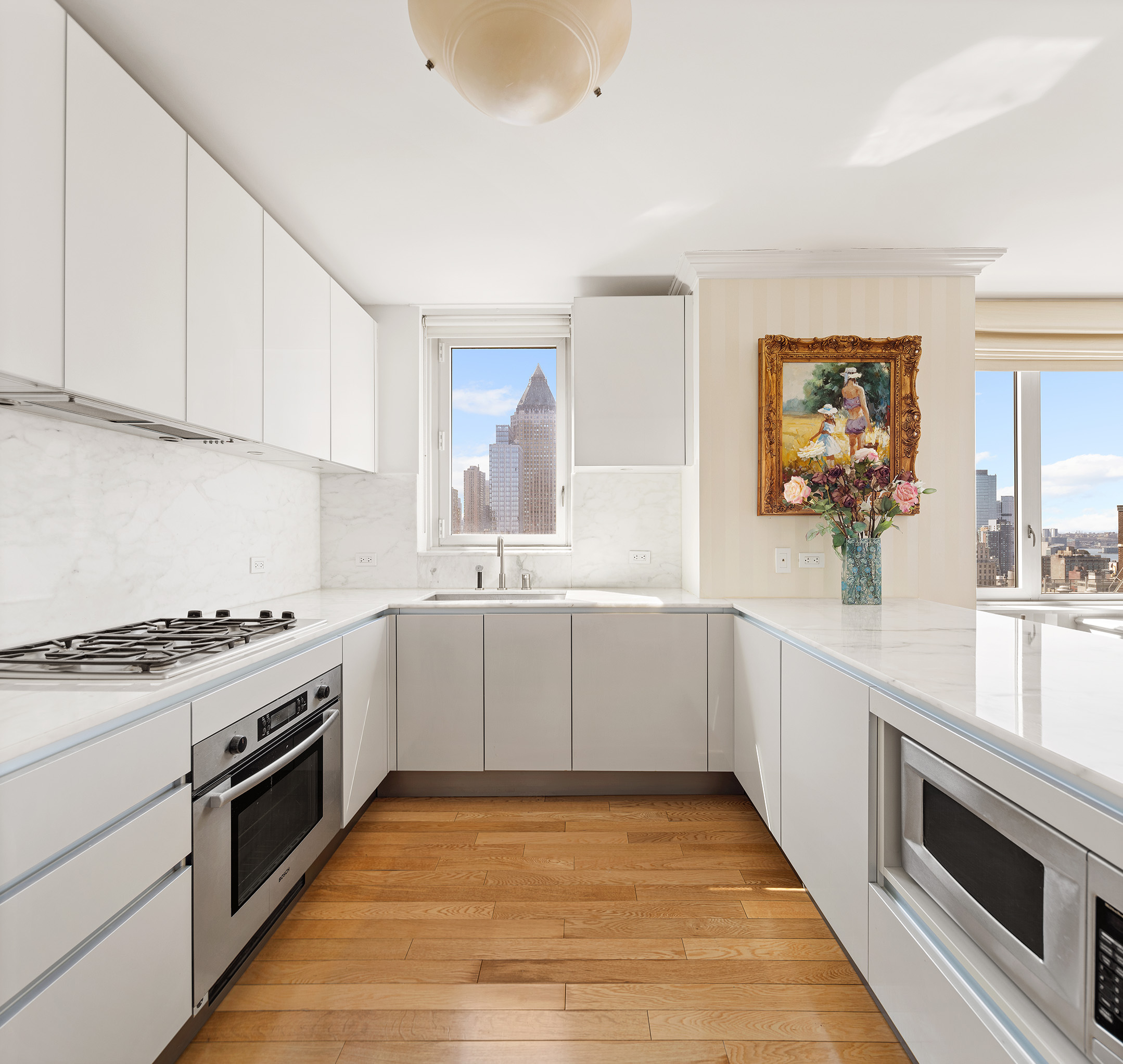 322 West 57th Street, Unit 33U Manhattan, NY 10019 - Photo 4 of 18 a kitchen with granite countertop white cabinets and white appliances