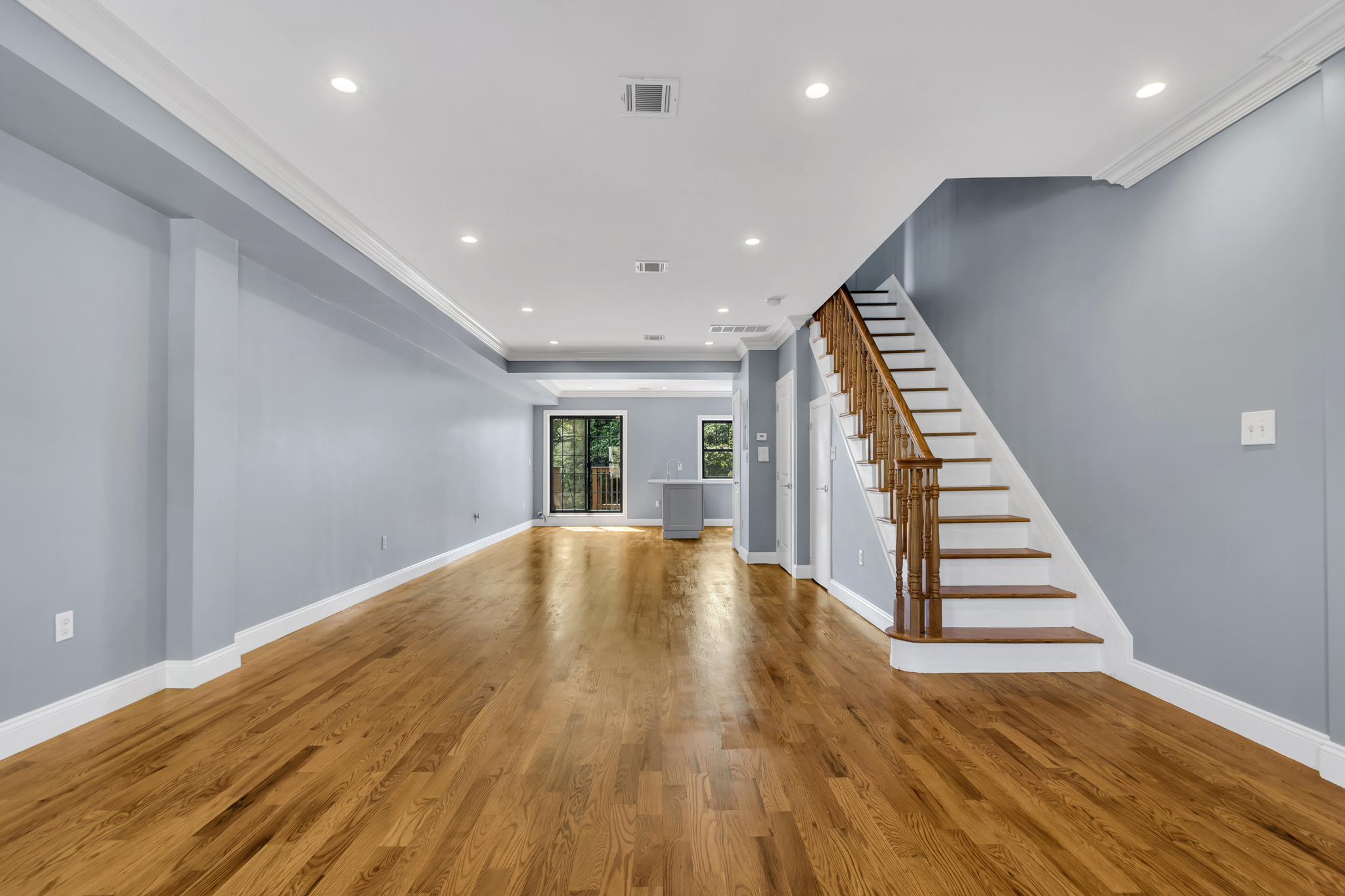 28 Roosevelt Place, Unit 2 Brooklyn, NY 11233 - Photo 6 of 12 a view of an empty room with wooden floor and stairs