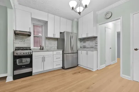 a kitchen with a refrigerator stove and wooden cabinets