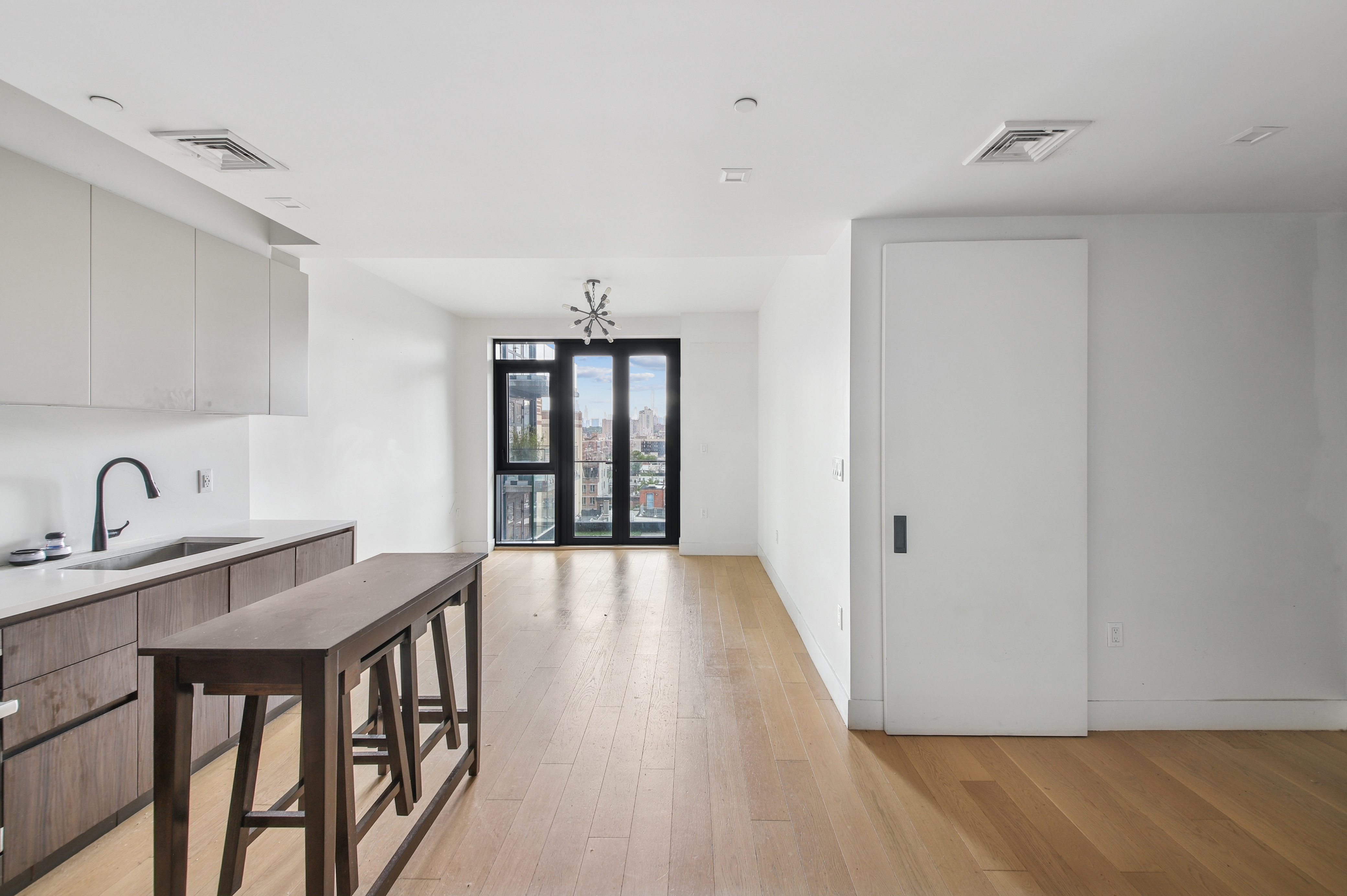 a view of a kitchen from the hallway with a dining room