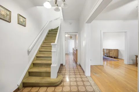 a view of a hallway with wooden floor and staircase