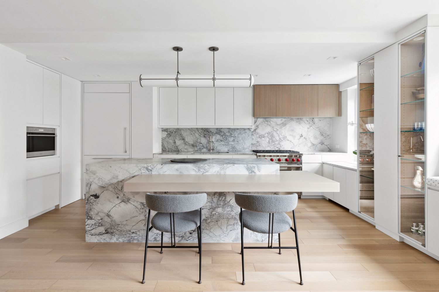 650 Park Avenue, Unit 9B Manhattan, NY 10065 - Photo 4 of 14 a kitchen with stainless steel appliances kitchen island a table chairs sink and cabinets