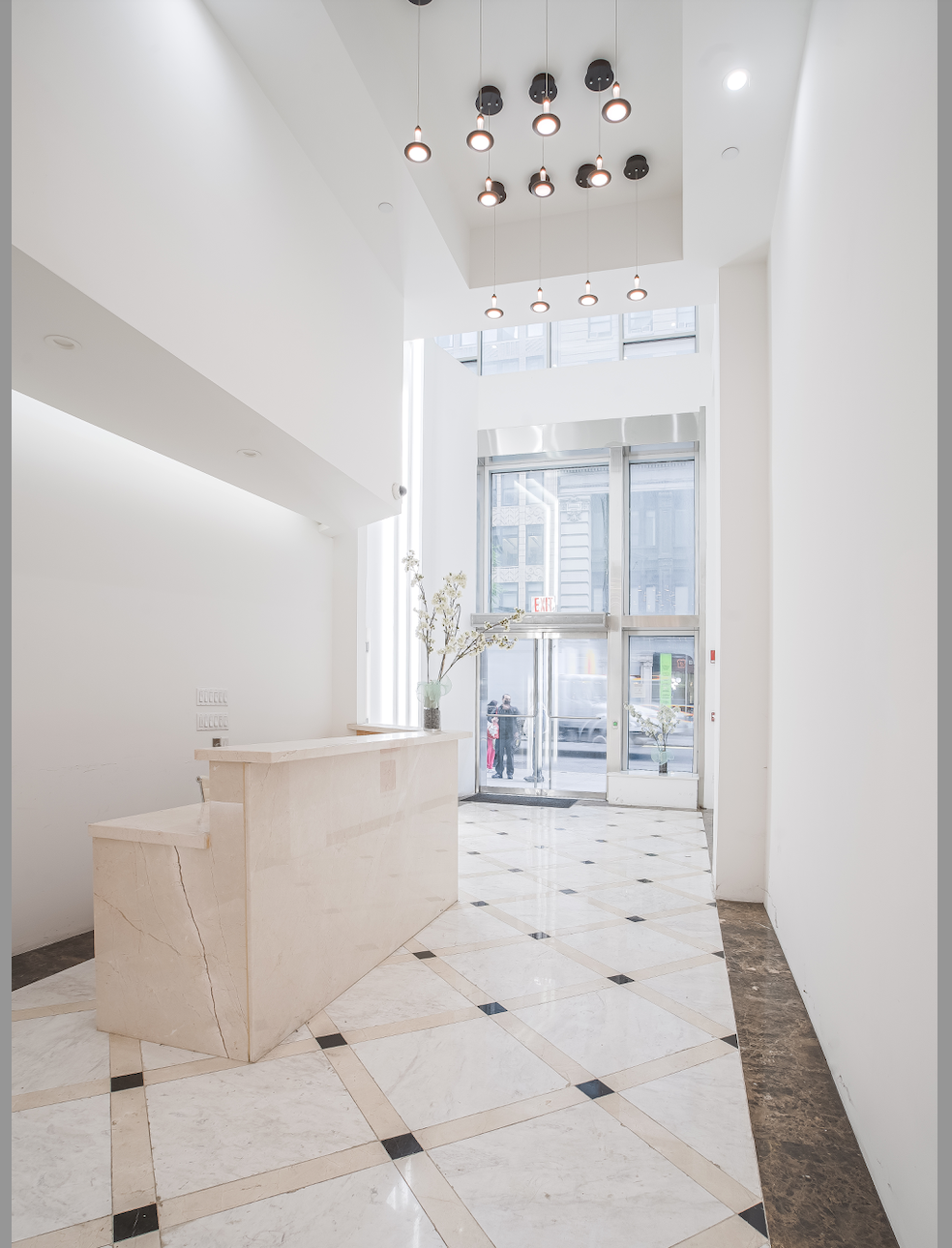 304 5th Avenue Manhattan, NY 10001 - Photo 2 of 6 a large white kitchen with granite countertop a white floor cabinets and a chandelier
