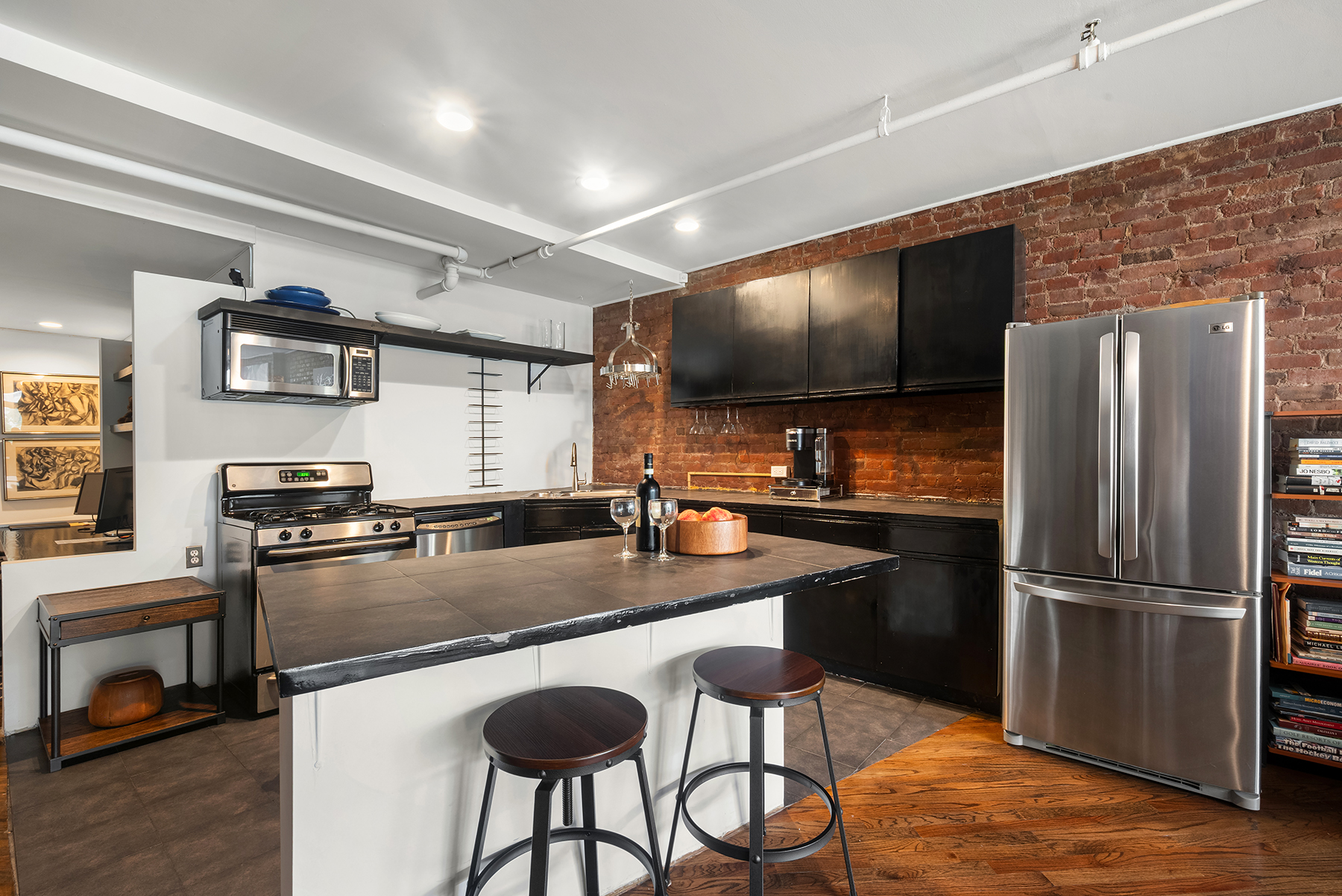 12 West 29th Street, Unit 4 Manhattan, NY 10001 - Photo 5 of 13 a kitchen with stainless steel appliances granite countertop a sink refrigerator and microwave